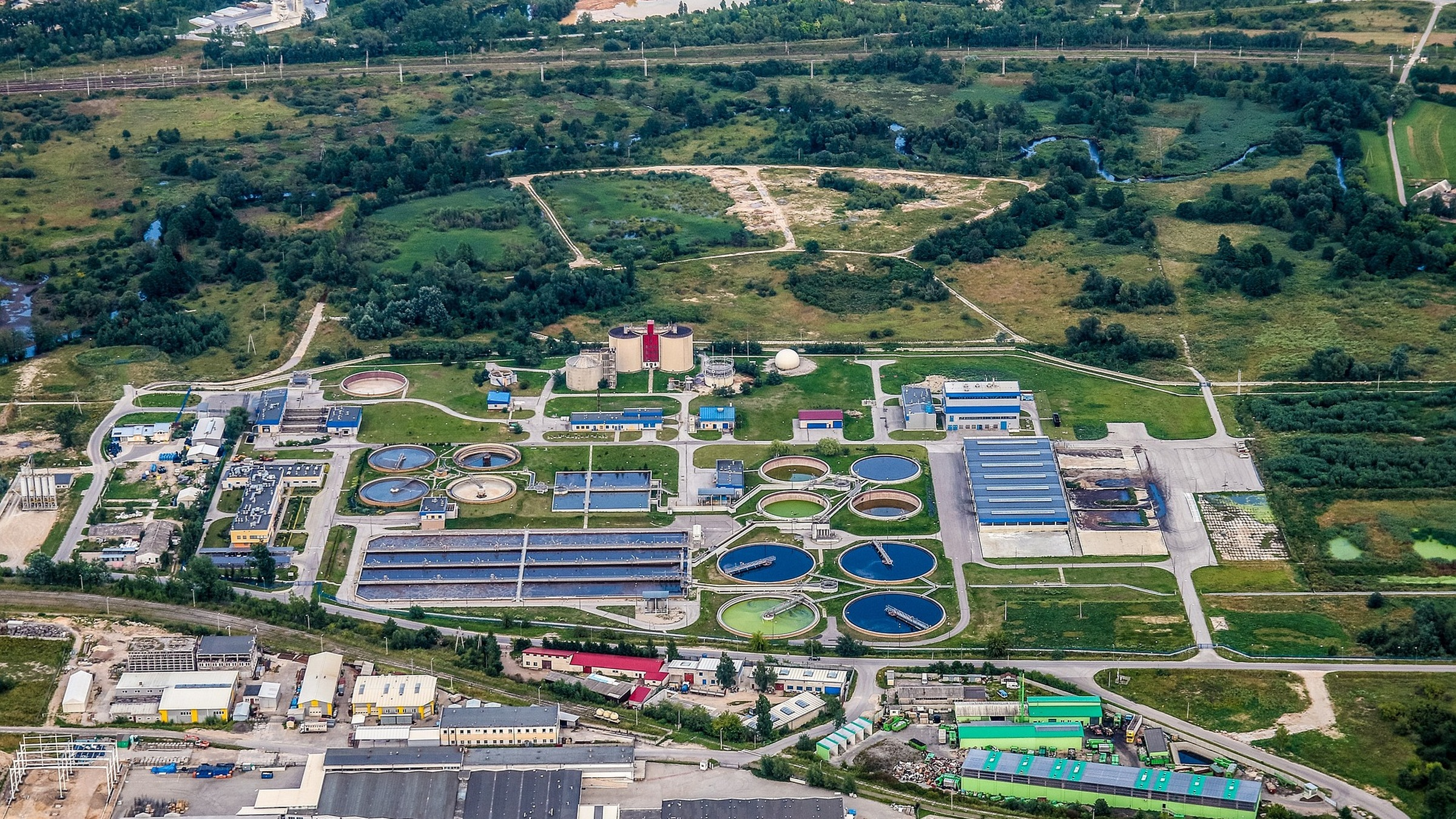 Aerial view of wastewater treatment basins, service buildings and pipework.
