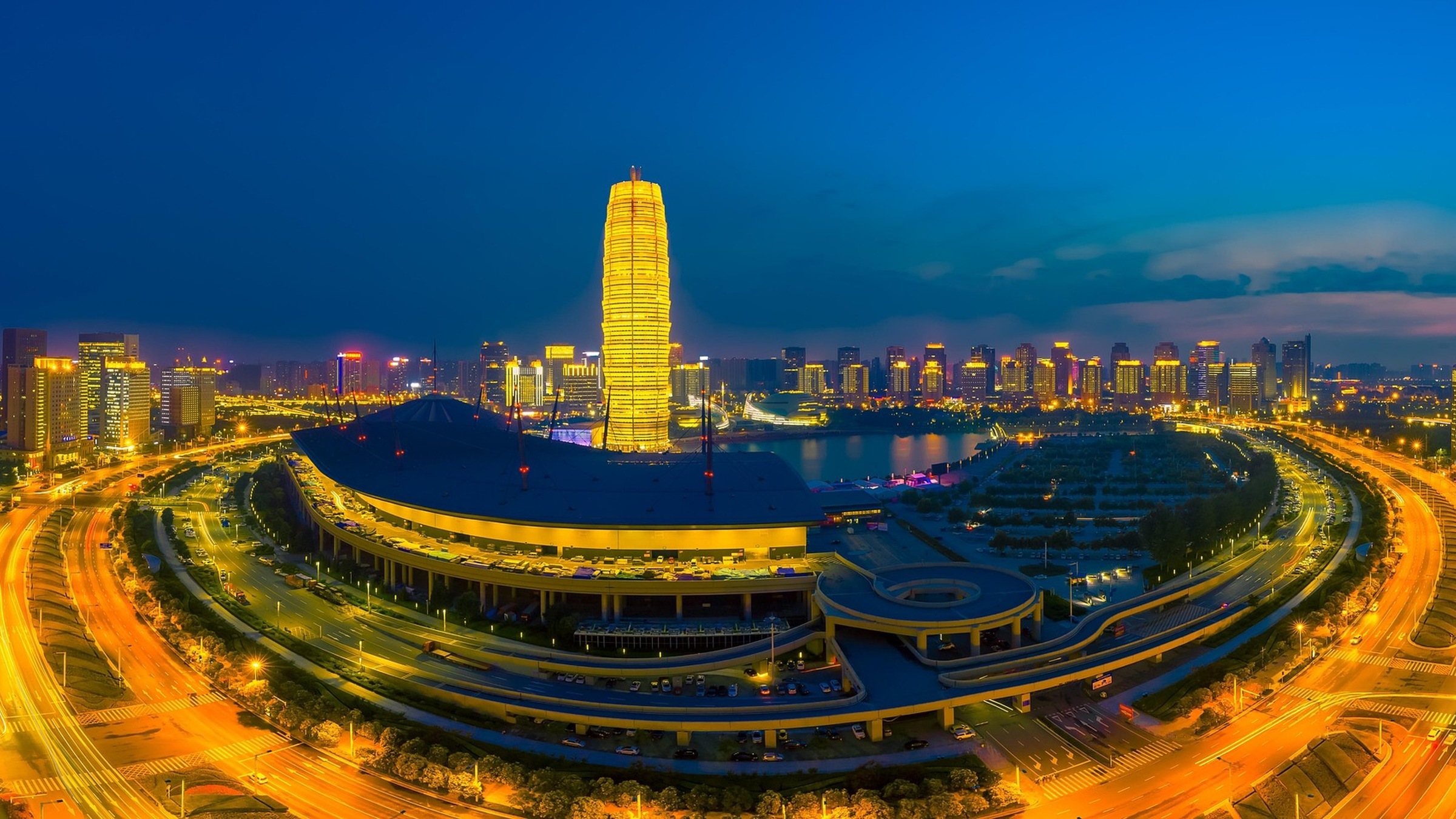Zhengzhou’s illuminated Millennium Plaza and surrounding roads at dusk.